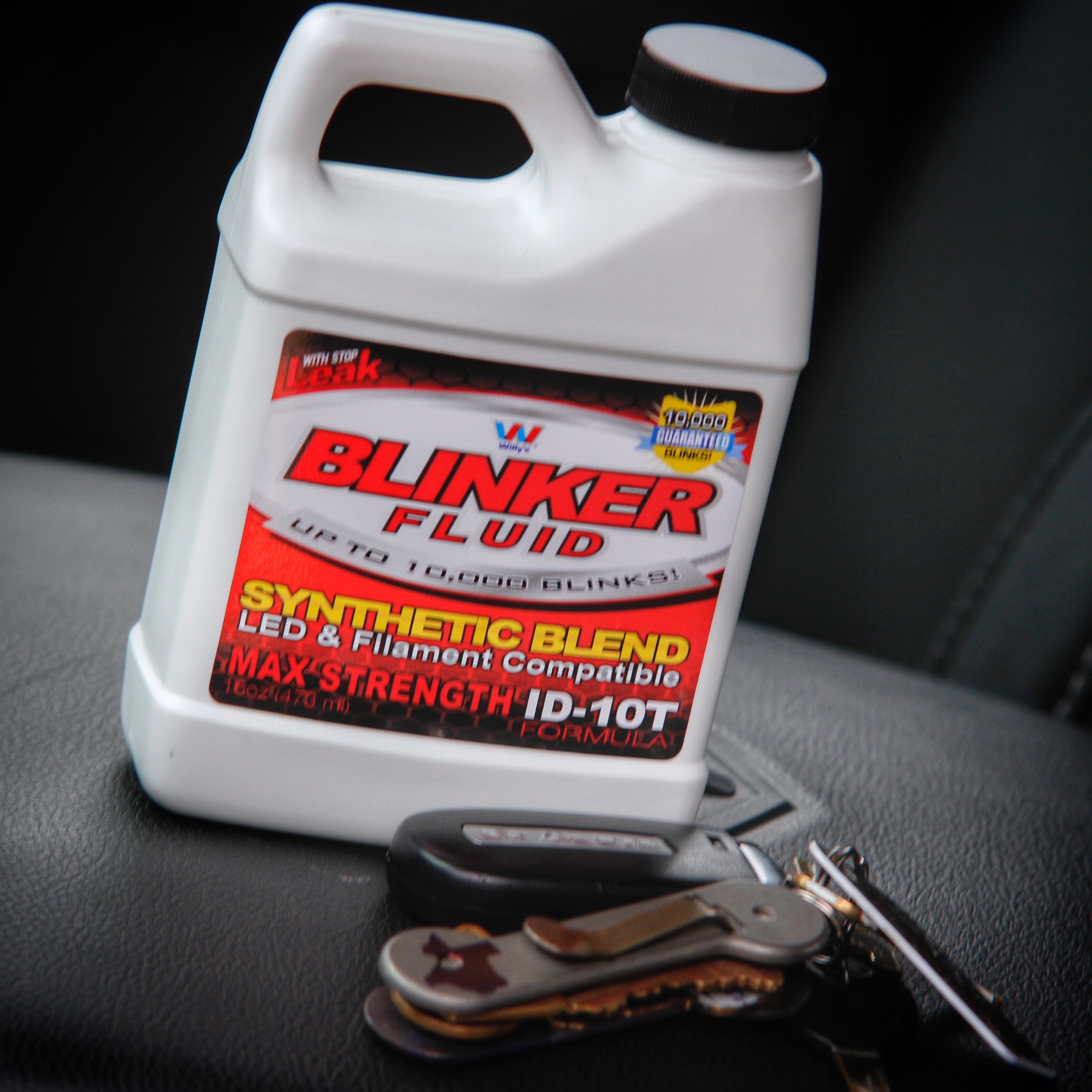 Blinker Fluid gag gift bottle displayed with a set of car keys